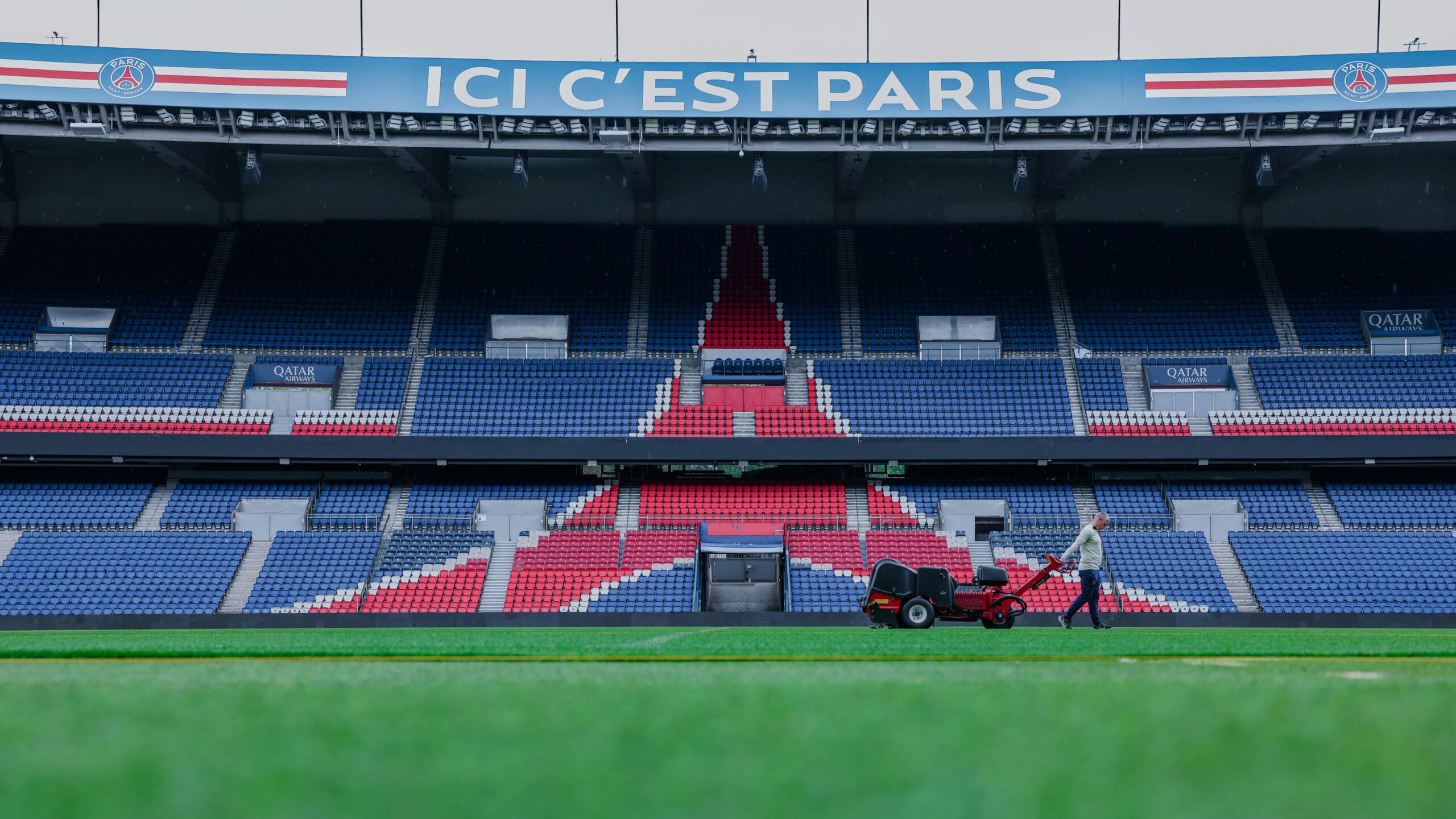 Gardener working on the field at Parc des Princes stadium, Paris. Vibrant and iconic sports venue.